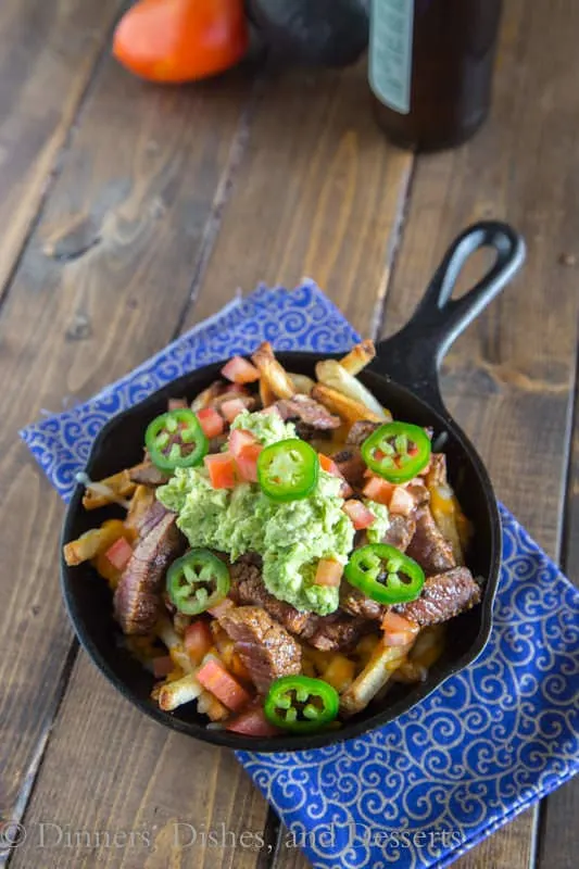 Carne Asada Fries - french fries topped with Carne Asada, melted cheese, and guacamole! A dinner that will please even your pickiest eater!