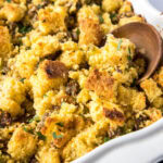 Close up of a wooden spoon in a casserole dish of stuffing