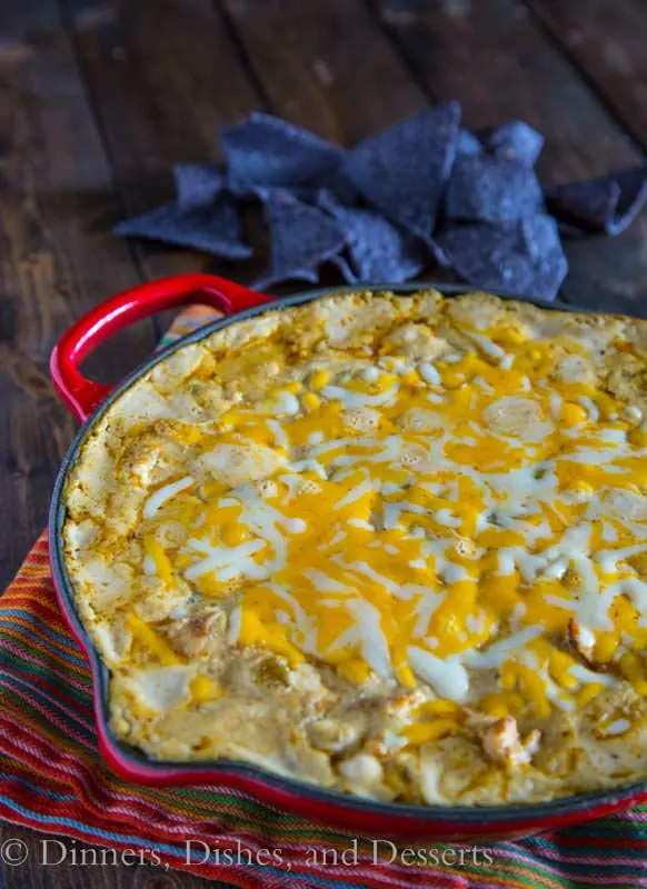 Green Chile Chicken Enchilada Dip - Bubbling hot gooey, cheesy enchilada dip. Turn your favorite green chile chicken enchiladas into a dip perfect for game day.