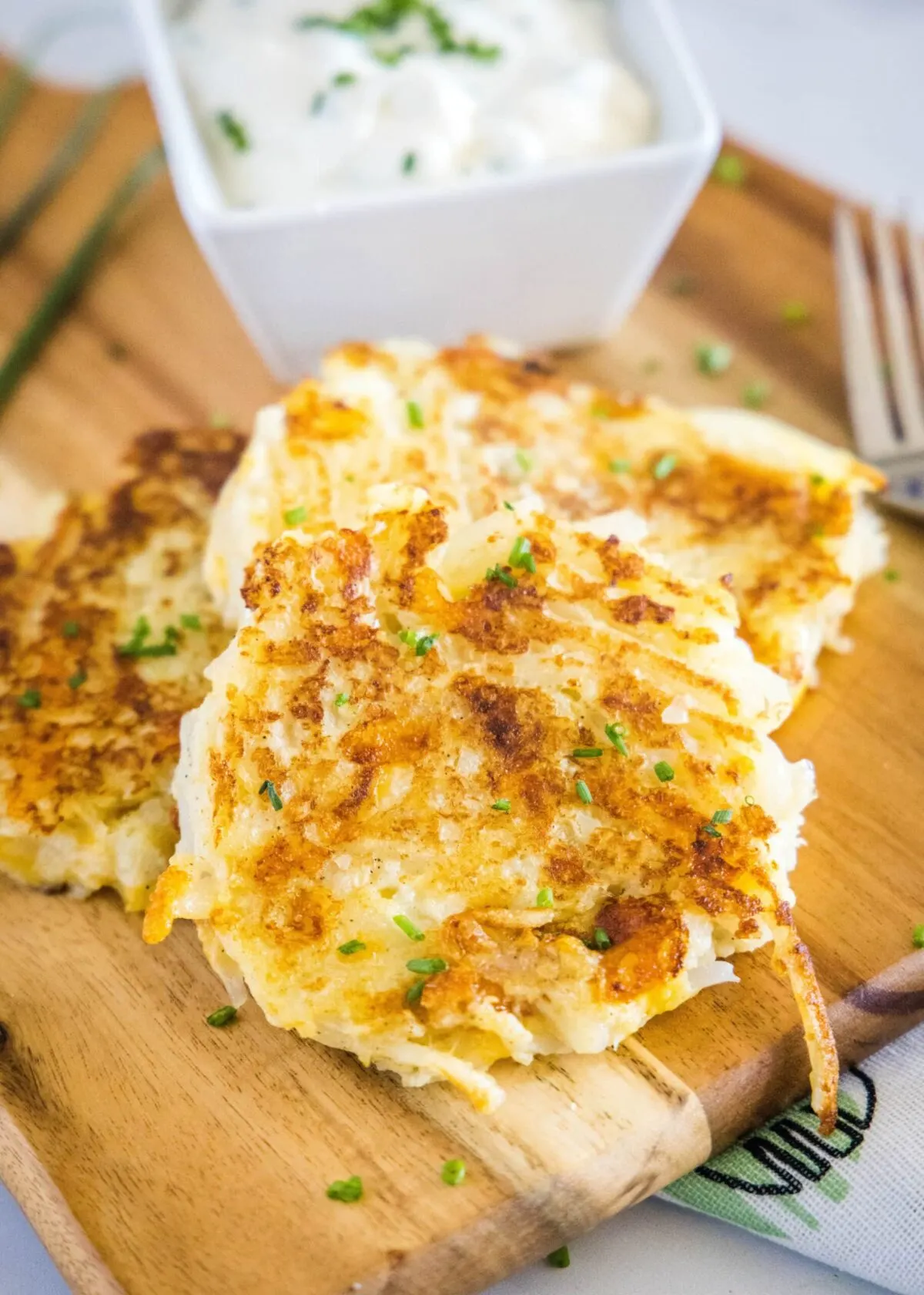 Close up of a stack of cauliflower fritters with a bowl of dipping sauce behind them