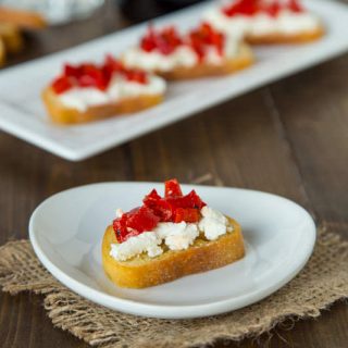 Piquillo Pepper and Goat Cheese Crostini - crispy crostini topped with goat cheese, chopped piquillo peppers and drizzled with balsamic vinegar. The perfect easy appetizer for any get together.