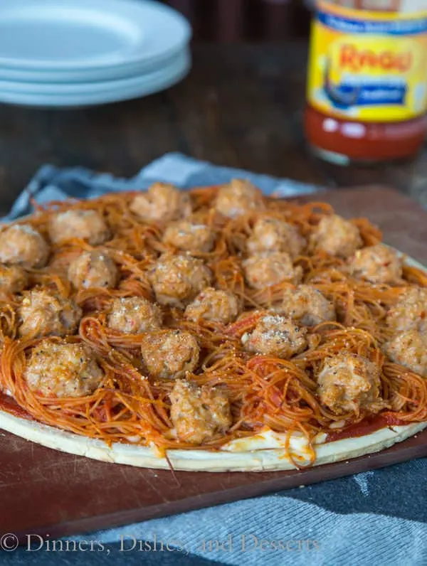 spaghetti and meatball pizza on a board