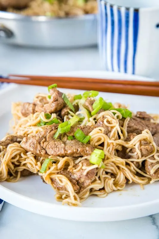 pork lo mein on a white plate with chop sticks