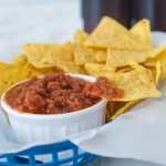 homemade salsa in a white bowl with chips
