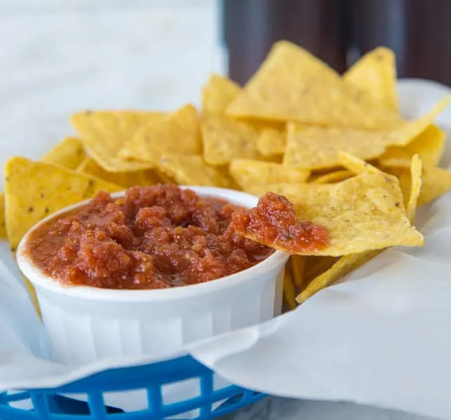 homemade salsa in a white bowl with chips