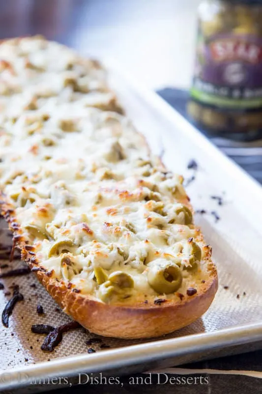 Garlic Olive Cheese Bread - take you garlic bread and turn it up a notch! Top it with Basil & Garlic flavored olives and lots of cheese!