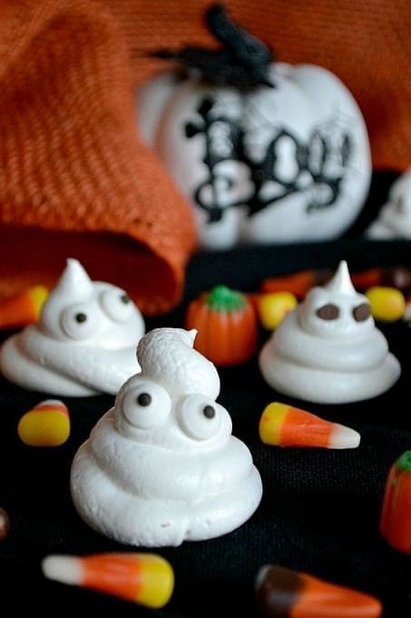 Close up view of halloween ghost meringues with candy eyes.