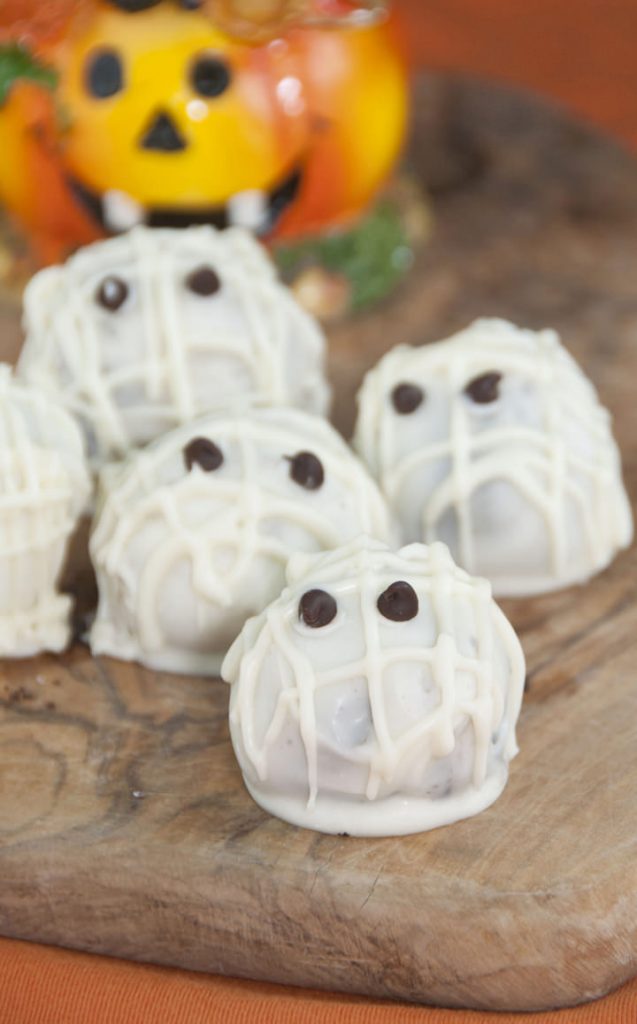 Angled view of halloween mummy oreo truffles covered in white chocolate.