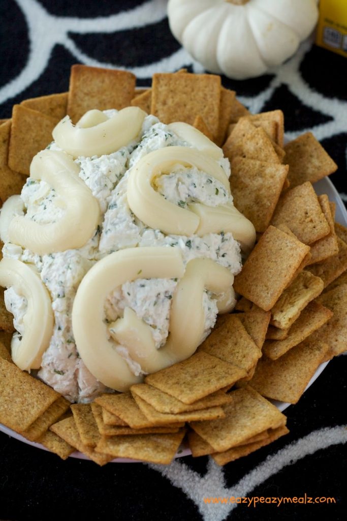 Above view of brain cheeseball with square crackers surrounding it.