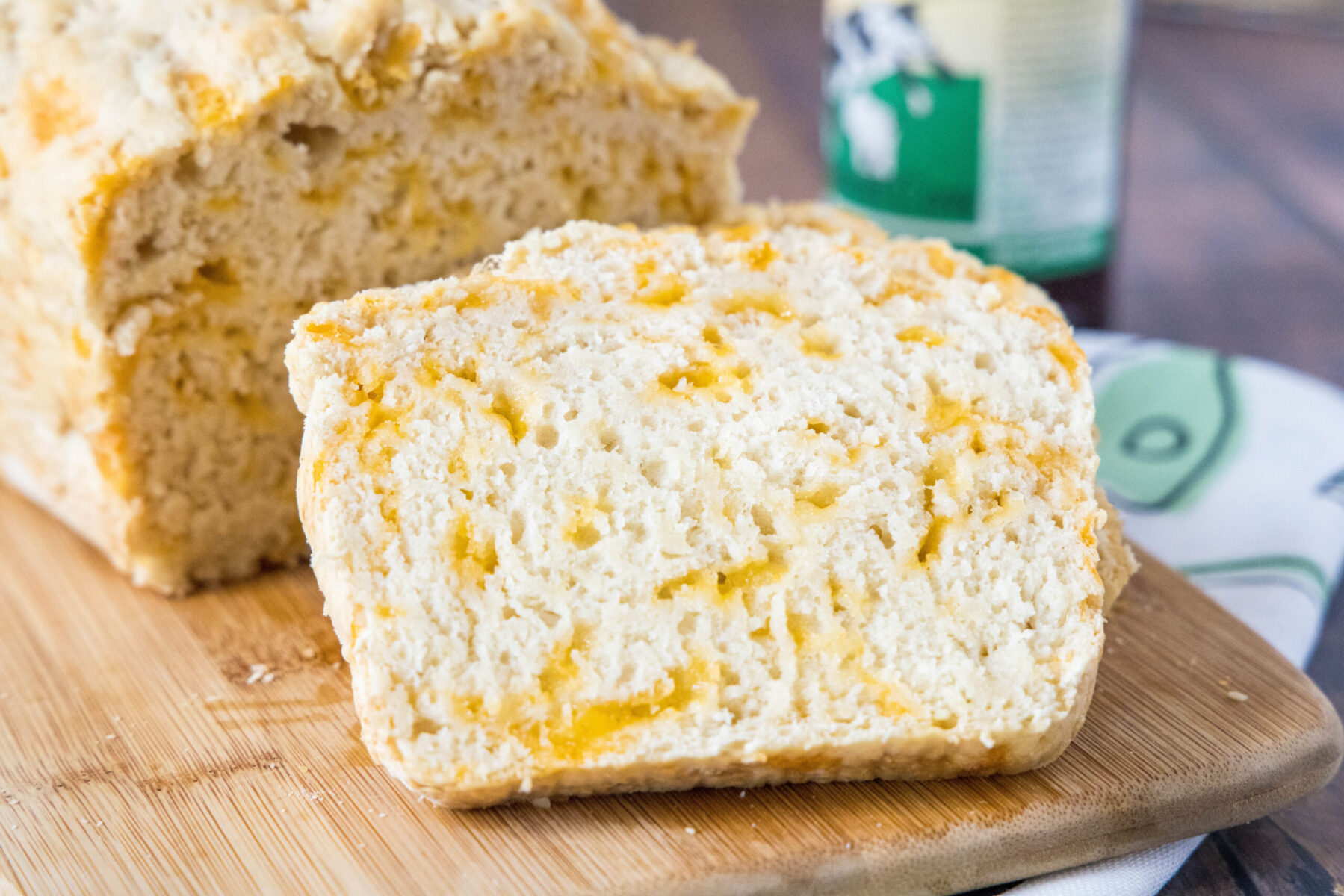 Close up of a slice of beer bread leaning against a loaf