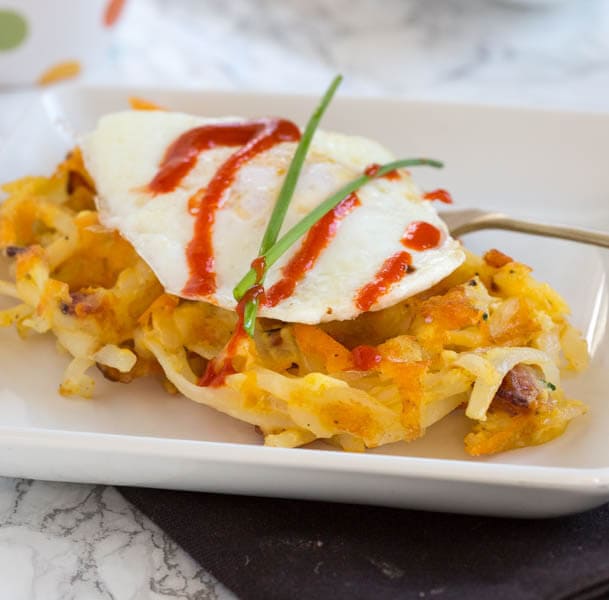 Bacon & Cheese Hash Brown Waffles - Make breakfast for dinner with these hash brown waffles that are crispy on the outside, filled with cheddar cheese and bacon! Top with a fried egg and hot sauce for breakfast perfection!