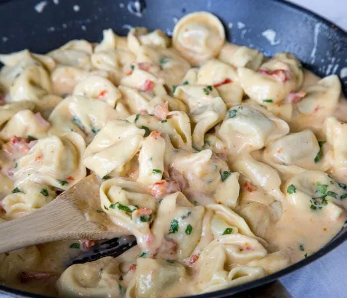 Tomato-Basil Pasta - a rich and creamy pasta dinner the whole family will love. Ravoili or Tortellini tossed in a sun-dried tomato cream sauce and plenty of fresh basil!