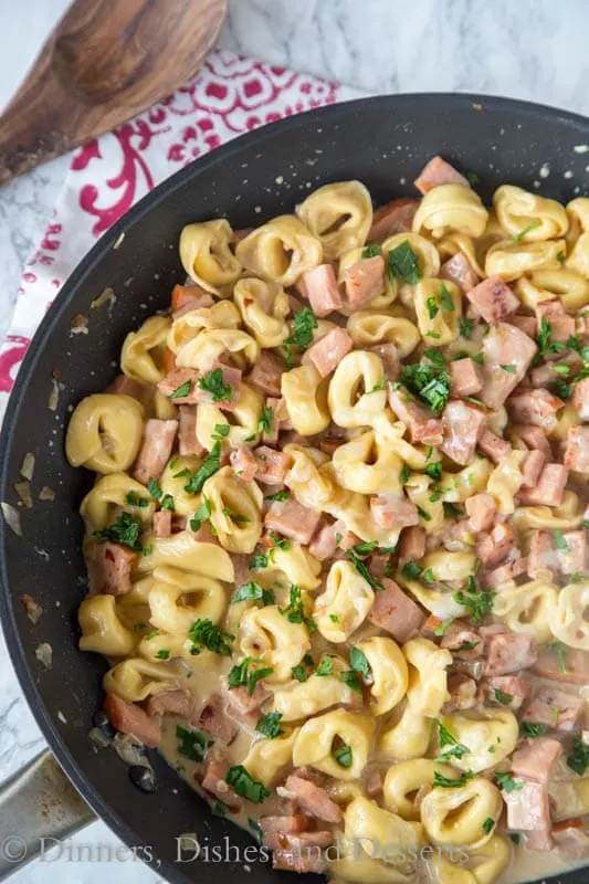 A pan filled with tortellini and ham