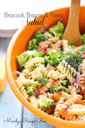 Broccoli Bacon Pasta Salad in an orange bowl with a wooden spoon