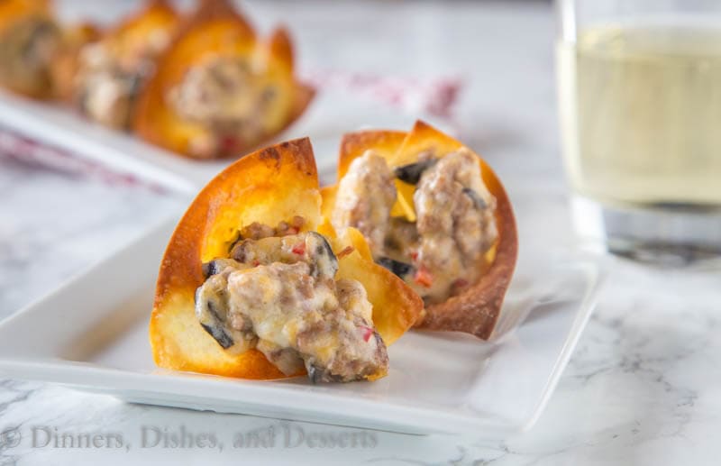 A close up baked wonton cups with sausage and cheese
