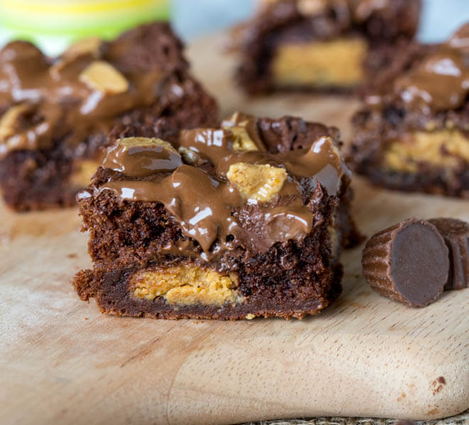 Peanut Butter Stuffed Brownies - rich, fudge brownies that are stuffed with peanut butter cups, topped with melted chocolate and more peanut butter cups!