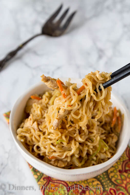A bowl of food on a plate, with Noodle and Chow mein