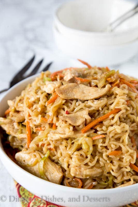 A bowl of food on a plate, with Chicken and Noodle