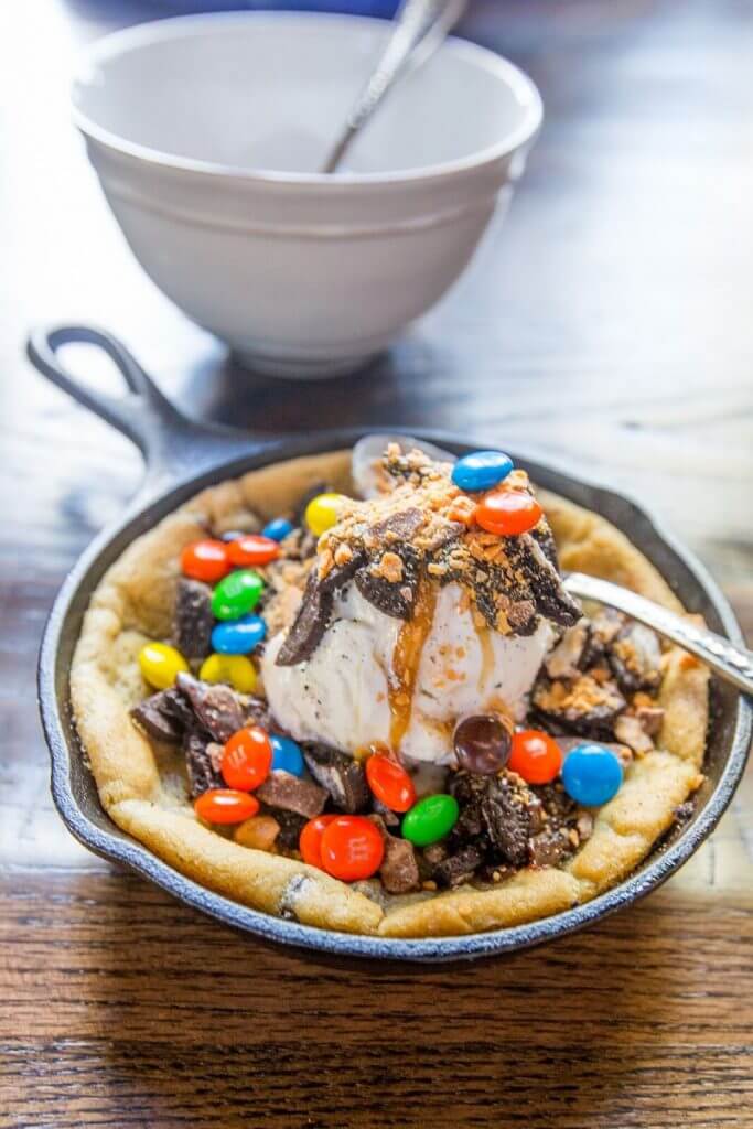 killet Cookie - ooey, gooey chocolate chip cookie baked in a skillet, and topped with ice cream, hot fudge, whipped cream and any other toppings your heart desires!