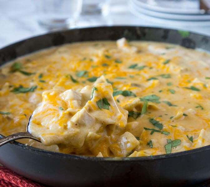 a skillet with chicken and cheese