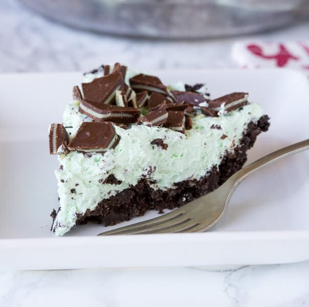 No Bake Mint Chocolate Chip Pie - a creamy mint pie with chocolate chips, topped with Andes mints, all in an Oreo crust! Such an easy no bake recipe for those hot days.