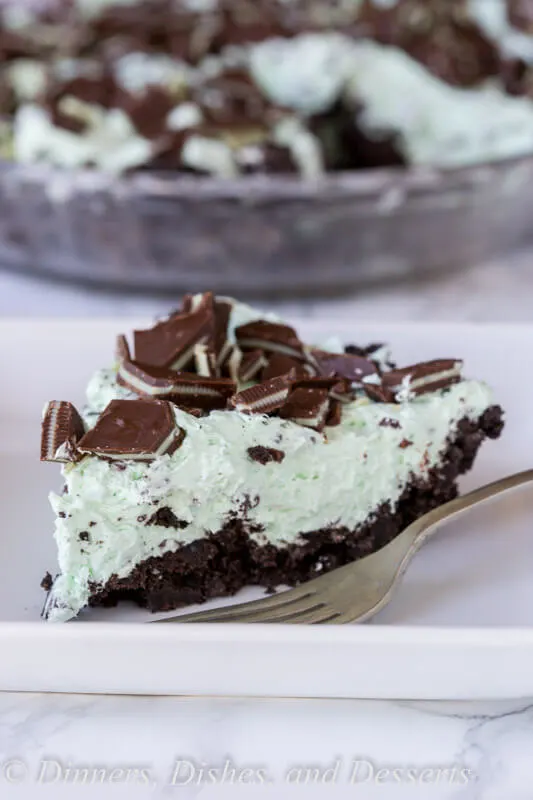 No Bake Mint Chocolate Chip Pie - a creamy mint pie with chocolate chips, topped with Andes mints, all in an Oreo crust! Such an easy no bake recipe for those hot days.