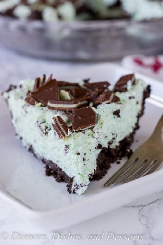 No Bake Mint Chocolate Chip Pie - a creamy mint pie with chocolate chips, topped with Andes mints, all in an Oreo crust! Such an easy no bake recipe for those hot days.