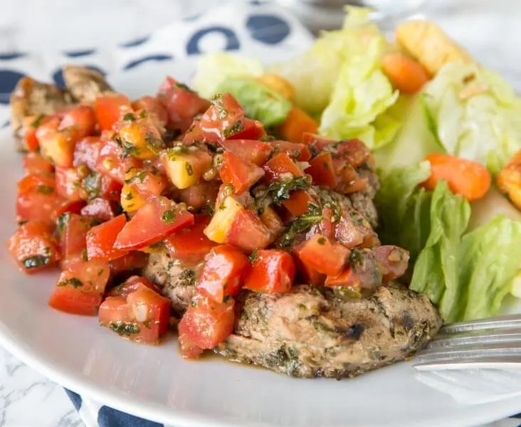 Bruschetta Chicken - chicken marinaded and grilled, then topped it tomato and garlic bruschetta. Healthy, quick, easy, and delicious!