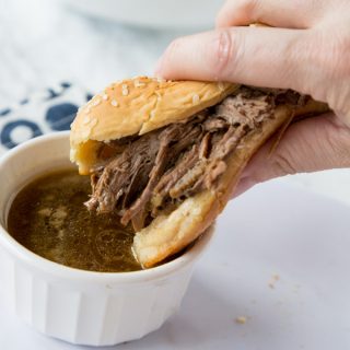 Slow Cooker French Dip Sandwich - Just 4 ingredients to make these super tender and delicious French dip sandwiches. They cook in the crock pot all day, so dinner is waiting for you!