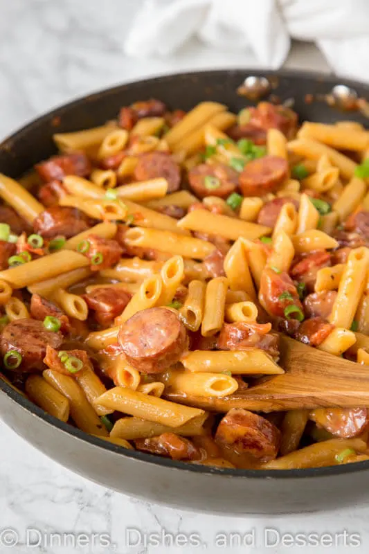 A dish is filled with food, with pasta and Sausage