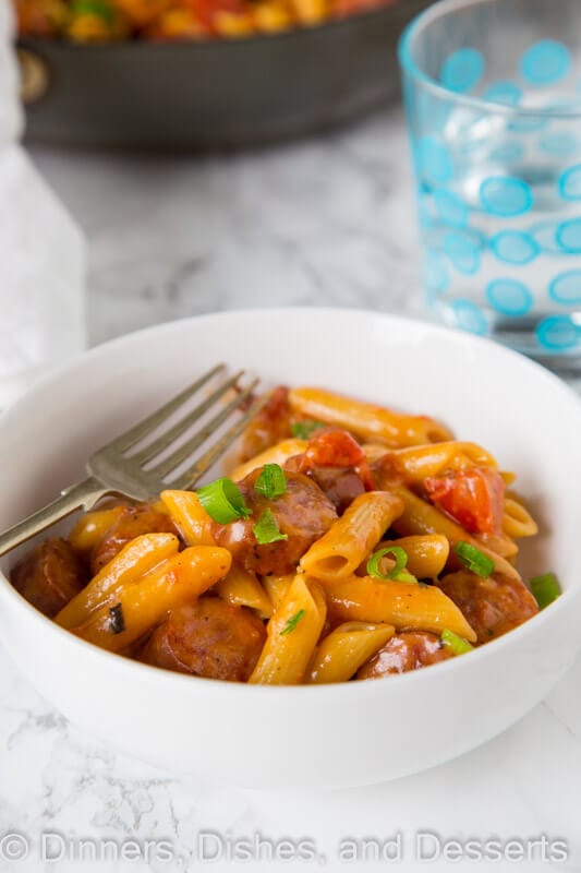 A bowl of food on a plate, with Sausage and Pasta