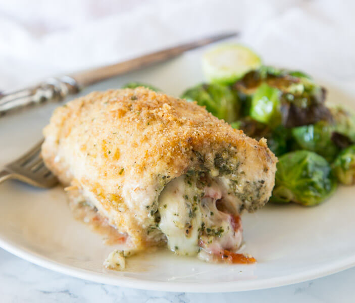 Italian Stuffed Chicken - chicken breasts rolled up with pesto, tomatoes, and cheese! Then baked until crispy and delicious, a great family dinner.
