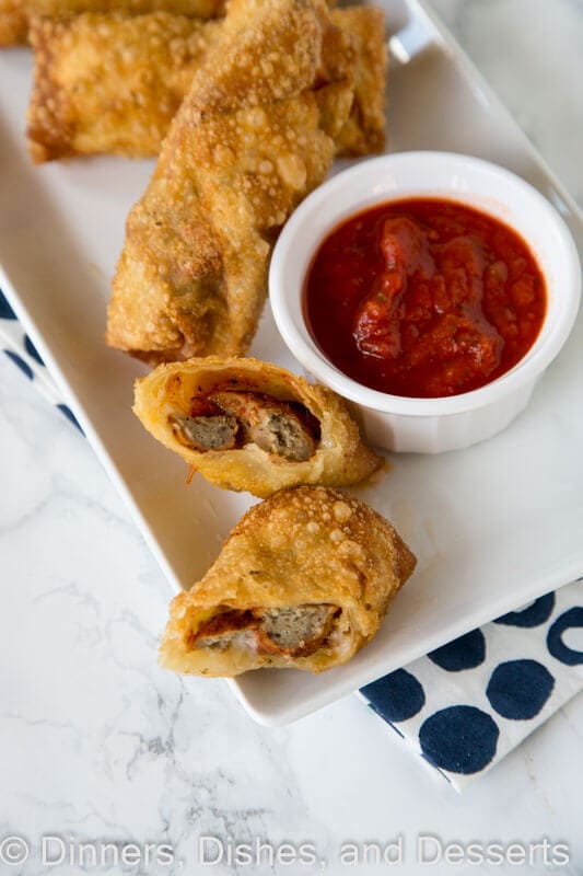 meatball sub egg rolls on a plate with dipping sauce