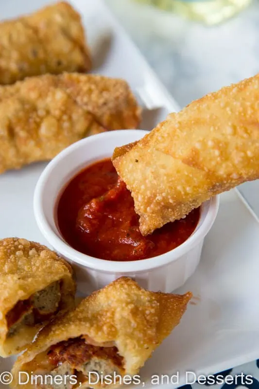 meatball sub egg rolls on a plate with dipping sauce