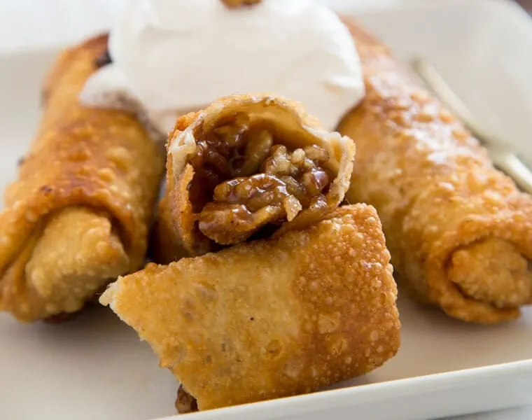 Pecan Pie Egg Rolls - instead of traditional pecan pie, turn it into something fun. Gooey pecan pie filling inside of a crispy egg roll and topped with whipped cream!