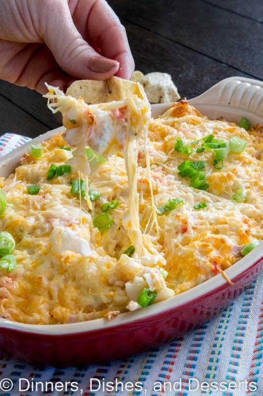 hot crab dip in a dish with a chip