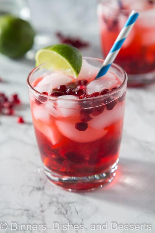 Pomegranate vodka gimlet in a cup with a straw