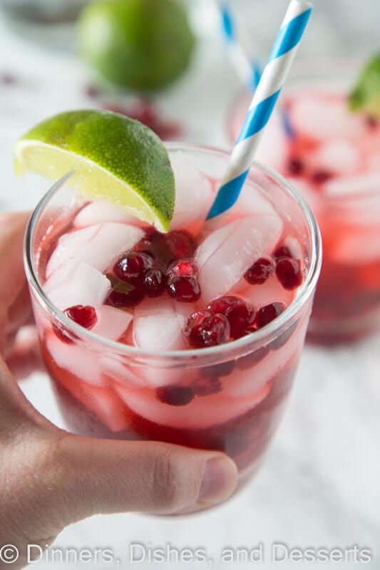 Pomegranate vodka gimlet in a cup with a straw