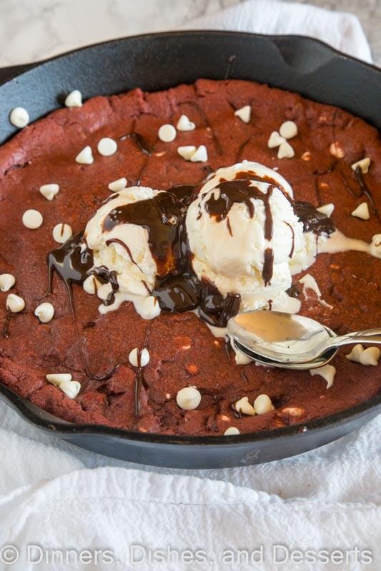 Red velvet skillet cookie in a skillet with a spoon