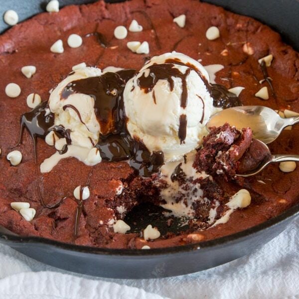 Red Velvet Skillet Cookie - a thick and chewy red velvet cookie baked in a skillet and topped with ice cream and hot fudge.