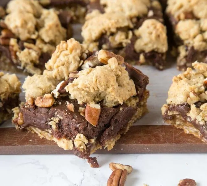 Fudge Nut Bars - an oatmeal cookie base topped with chocolate fudge, lots of nuts, and then more oatmeal cookie baked on top! Gooey and so good!