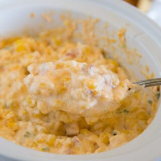 corn dip in a slow cooker with serving spoon