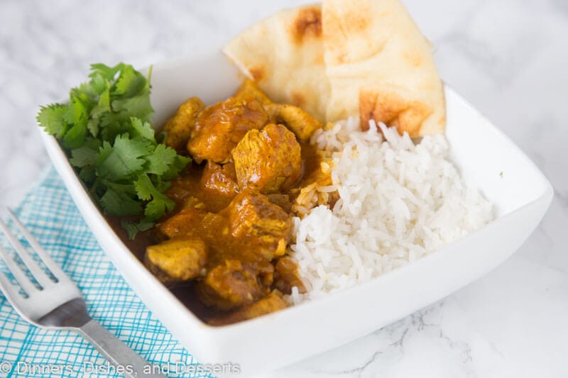 A plate full of food, with chicken Curry and rice