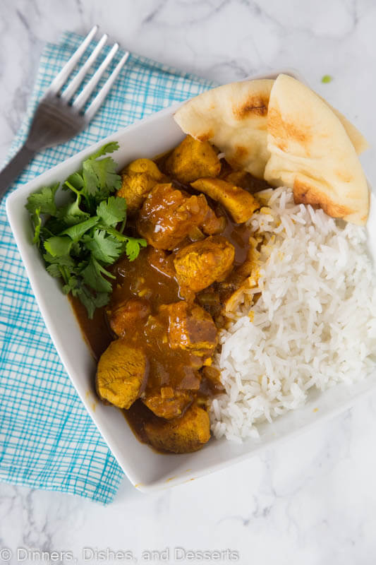 A plate full of food, with chicken Curry and rice