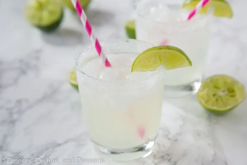 margarita in a glass with lime wedge and pink straw