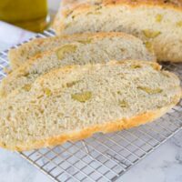 A piece of bread on a plate, with Olive