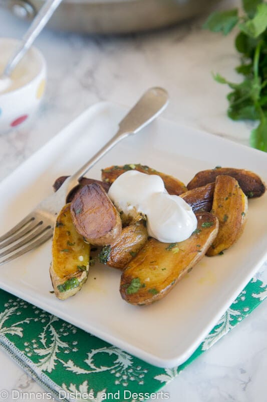 A plate of food on a table, with Potato topped with sour cream