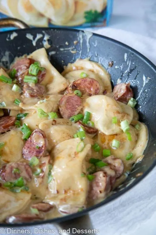 A close up of a plate of food, with Pierogi and Sausage