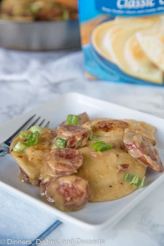 A plate of food on a table, with Pierogi and Sausage