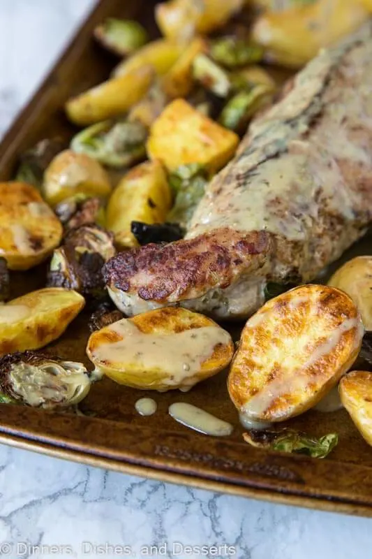 A close up of food, with Pork tenderloin with potatoes and brussels sprouts